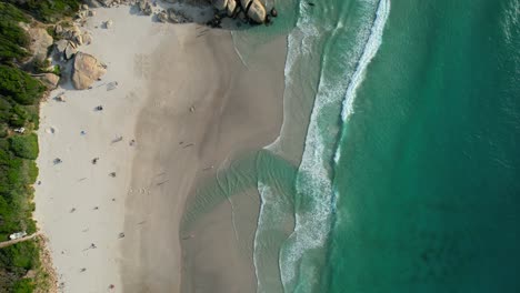 Pocos-Turistas-Relajándose-En-La-Playa-De-Arena-Blanca-De-Llandudno-Con-Hermosas-Olas-Rompiendo,-Antena