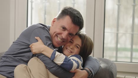 a father and son sharing a loving embrace and kiss at home