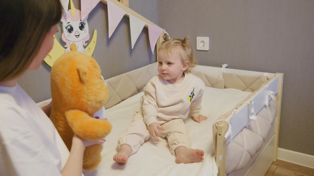 Bambina felice che gioca con la madre in una culla accogliente