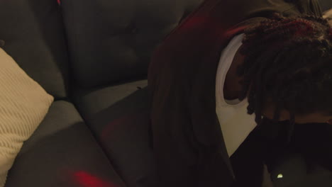 hombre despertando en el sofá después de beber alcohol en la fiesta de la casa sufriendo de resaca hablando en el teléfono móvil 2