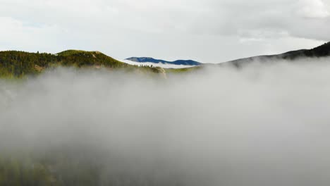 low clouds and fog over colorful rocky mountain alpine valley