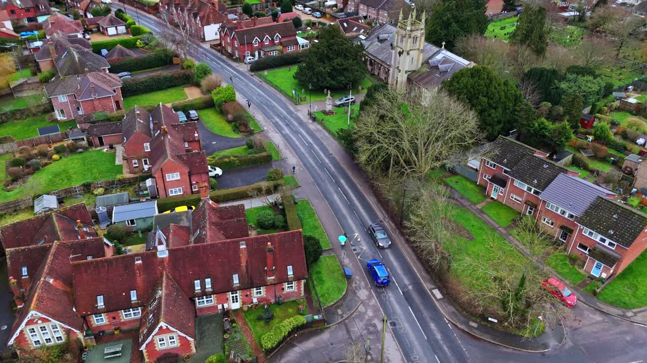 En panoramisk droneoptagelse fra luften over forstæderne til Southampton, med Botley landsbys boliger ved solnedgang på en overskyet vinterdag, med biler der passerer forbi på vejene nedenfor, forbi den lille bebyggelse i byen.