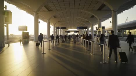 travelers navigate through a bustling airport terminal as the sun sets, casting warm light on the sleek architecture and bustling travelers. carts and luggage surround the moving crowd.
