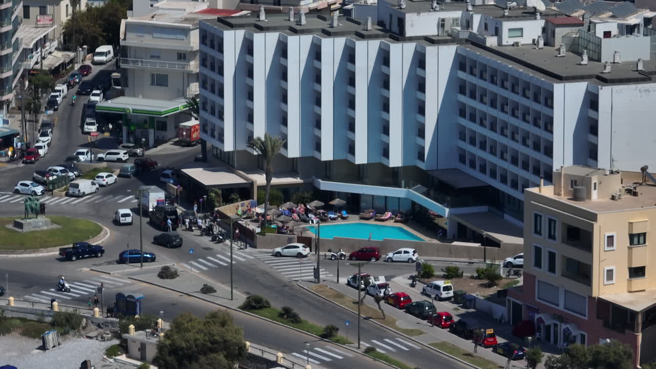 Telephoto drone shot of traffic at a roundabout in Rhodes city, sunny day in Greece