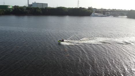 Vuelo-Lateral-De-Drones-Cerca-De-Un-Jetsky-Que-Viaja-Sobre-El-Agua