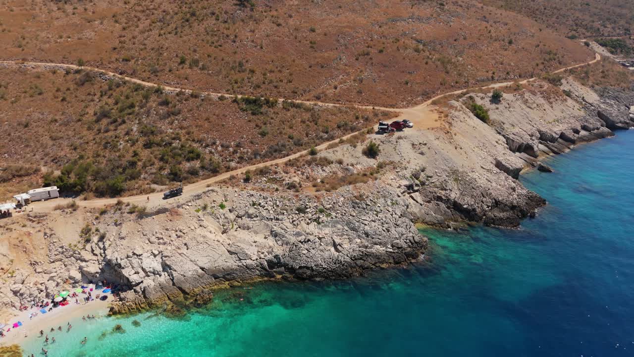 Remote rocky coastline of Albania with clear blue waters and scenic cliffs on a sunny day