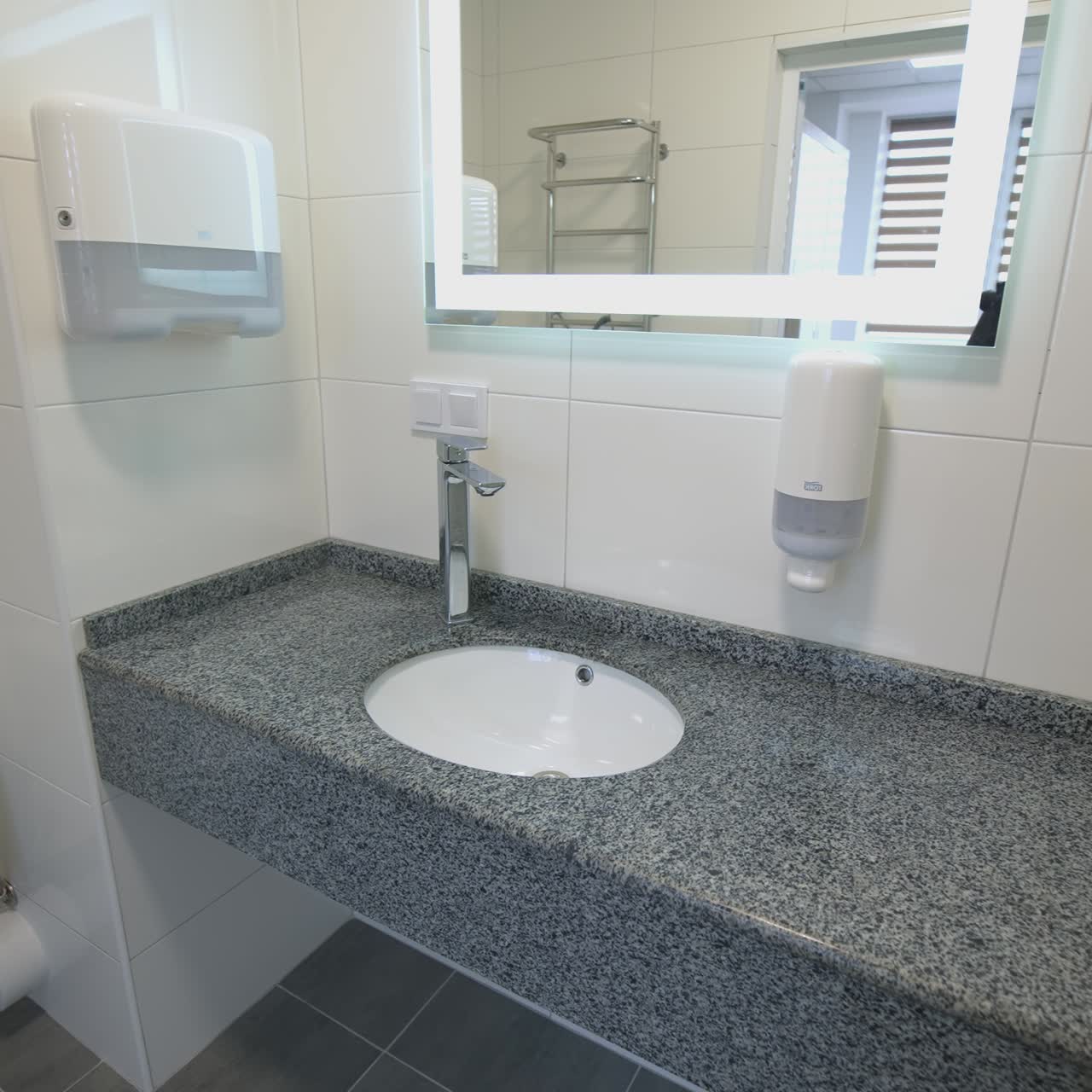 Clean lavatory with modern design of water basin. Toilet indoors in the hospital or hotel. Sterile washroom with a mirror