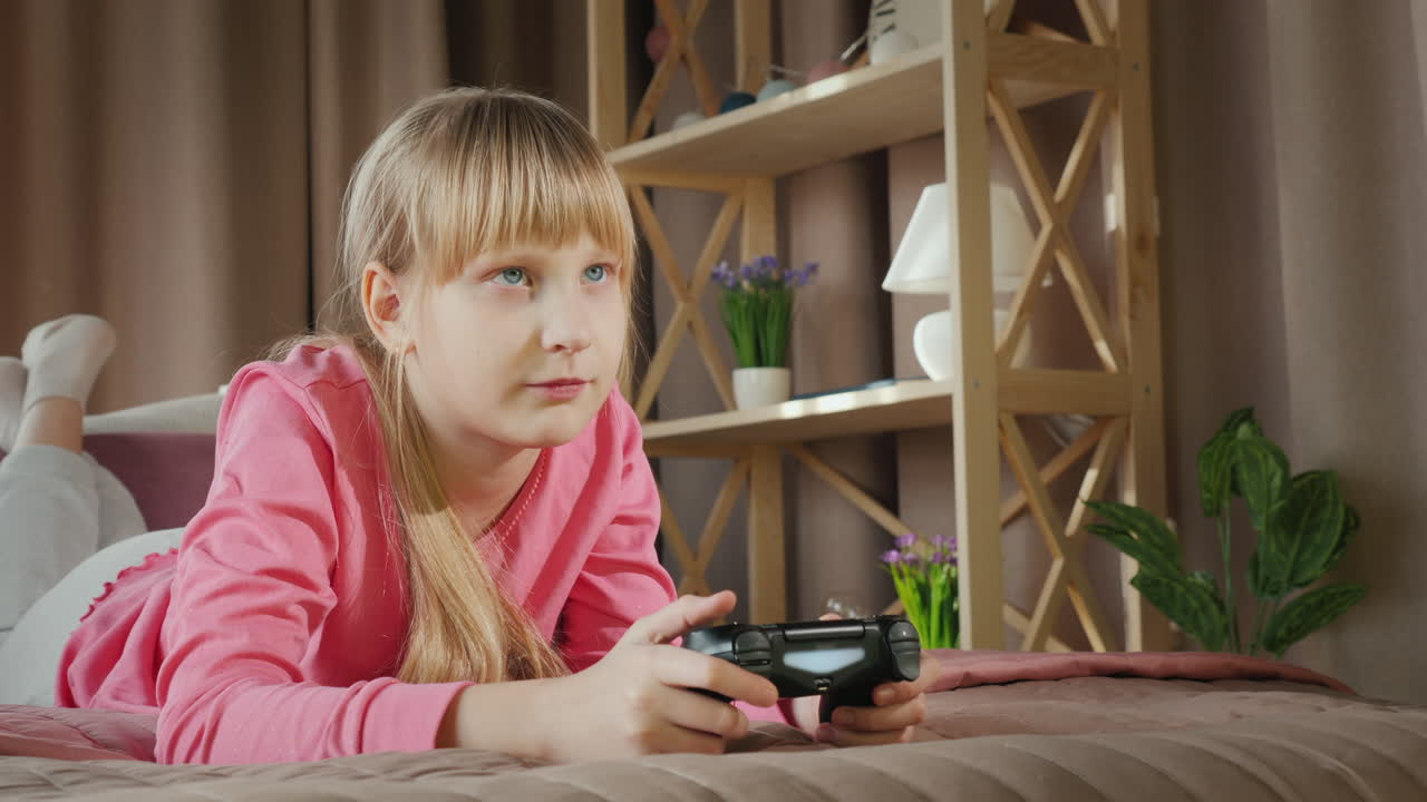 금발 소녀는 콘솔에서 비디오 게임을 합니다.