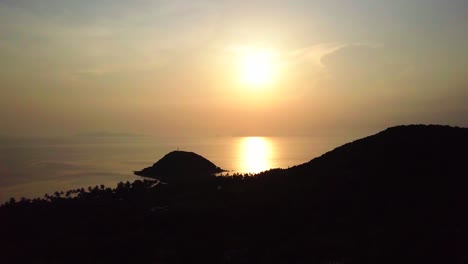 air flight over island and sea at sunset