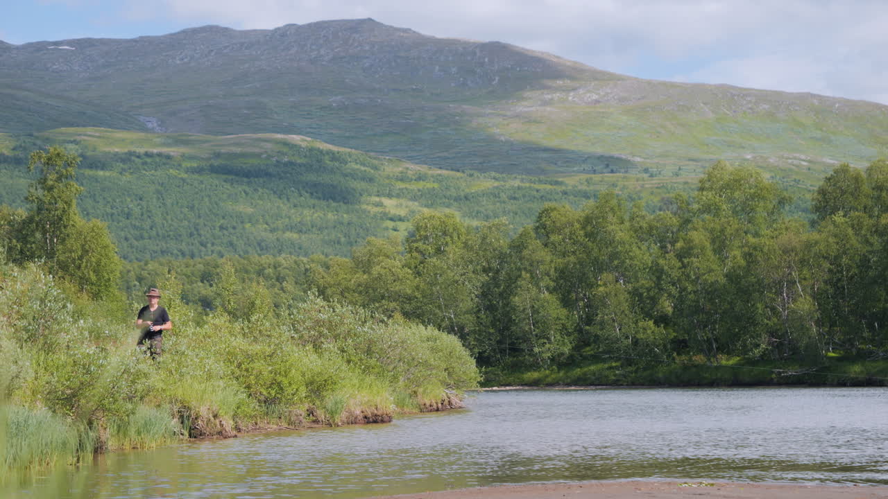 мужчина ловит рыбу среди прекрасного лапландского пейзажа летом, швеция
