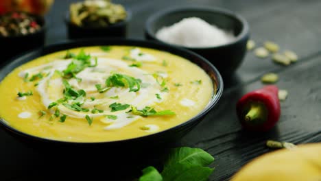 Pumpkin-soup-in-bowl-sprinkled-with-herbs