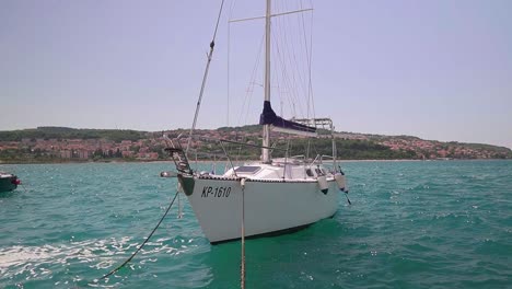 Stunning-HD-footage-captures-a-sailboat-gently-swaying-in-Koper's-marina,-amid-the-waves-of-the-Adriatic-Sea