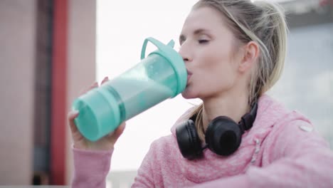 handheld view of woman drinking protein drink after workout