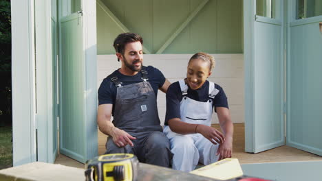 couple taking a break from building outdoor summerhouse in garden