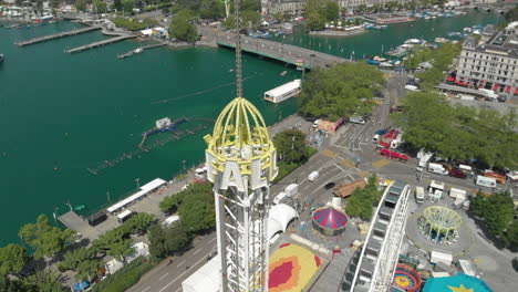 aerial drone shot orbiting around amusement park free fall tower in zürich, switzerland during zürichfest