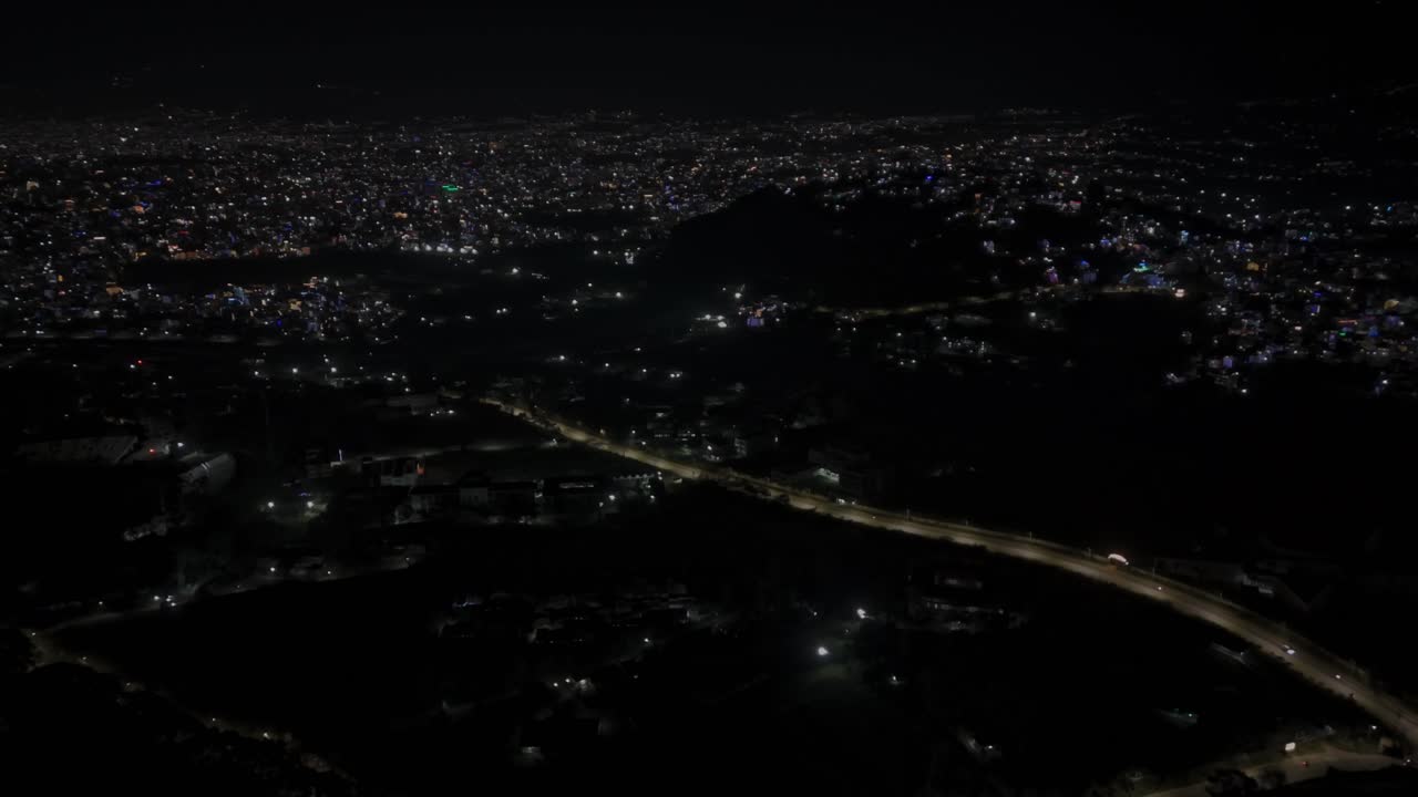 Aerial night footage of Kathmandu city during Diwali (Tihar), featuring the illuminated Dharahara Tower and glowing skyline filled with festive lights, showing Nepal’s vibrant cultural celebration