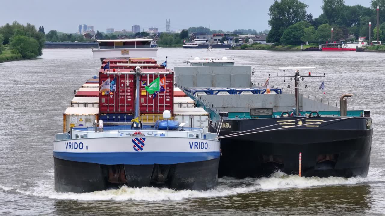 Two Cargo Ships, Including a Container Vessel, Navigating a River