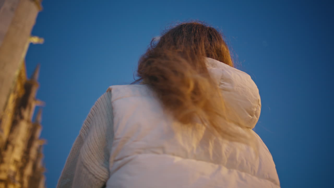 행복한 여성 사진작가는 저녁 도시를 즉각적인 카메라 클로즈업으로 포착합니다.