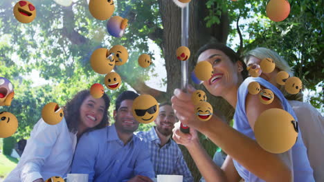 smiling friends at picnic table with floating emoji animation over them