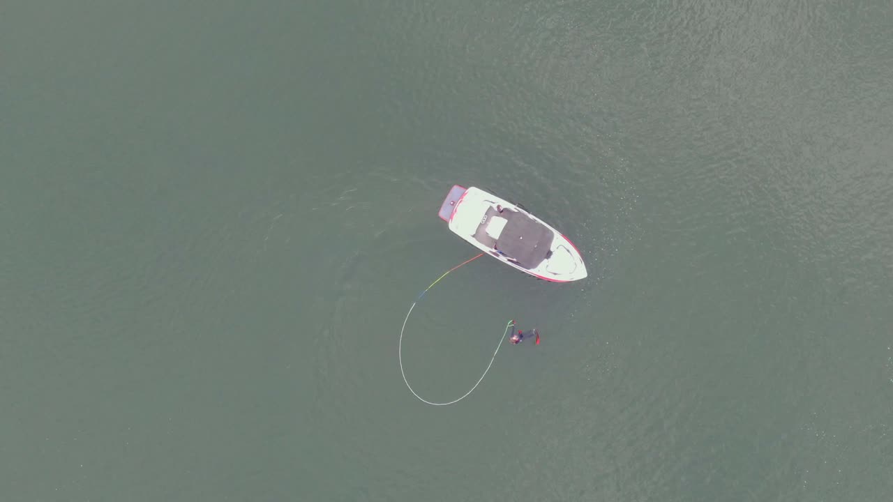 Aerial view of a person in water with a boat, likely preparing for a water sport