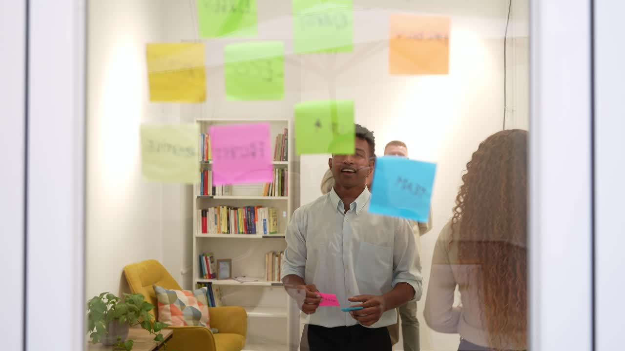 Diverse Business Team Brainstorming with Sticky Notes on Glass Wall