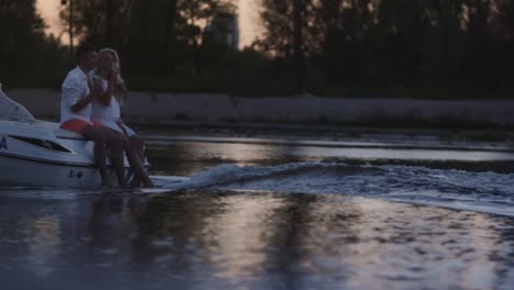 Encantadora-Pareja-Bebiendo-Champán-En-Un-Barco-A-Motor-Flotante.-Cita-Romántica