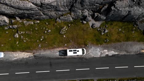 A-camper-van-with-solar-panels-is-parked-next-to-a-road-in-The-Burren,-County-Clare,-Ireland-along-the-Wild-Atlantic-Way