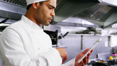 chef masculino usando una tableta digital en una cocina comercial