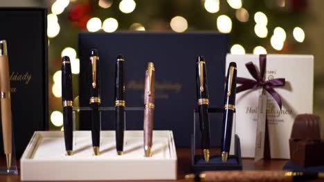 elegant collection of luxury pens displayed with chocolate gifts, perfect for special occasions and celebrations with a festive background of bokeh lights