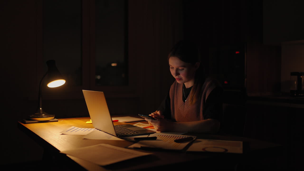 hermosa mujer trabajando hasta tarde en casa usando una computadora portátil y recibiendo mensajes de texto en el teléfono inteligente. manos de mujer enviando mensajes de texto en el teléfono móvil inteligente para la comunicación y el chat en línea social