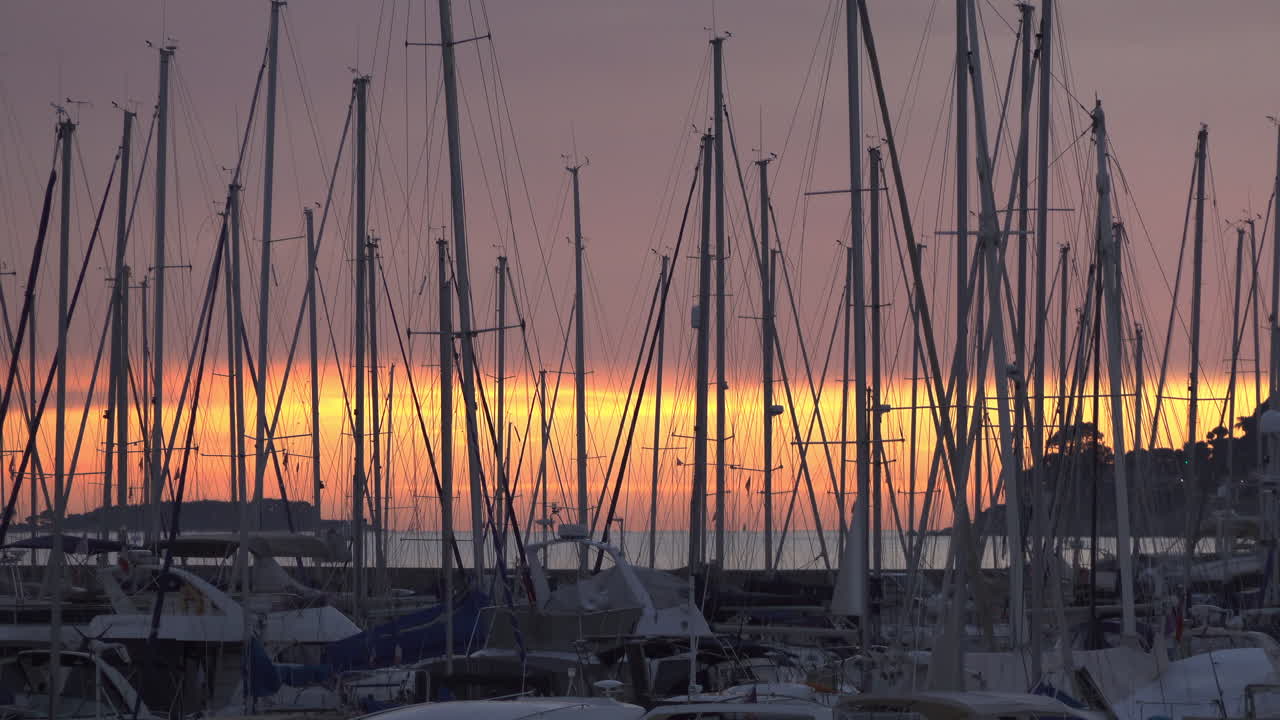 Antibes, France - March 21, 2025: Multiple boats docked in the port at sunset