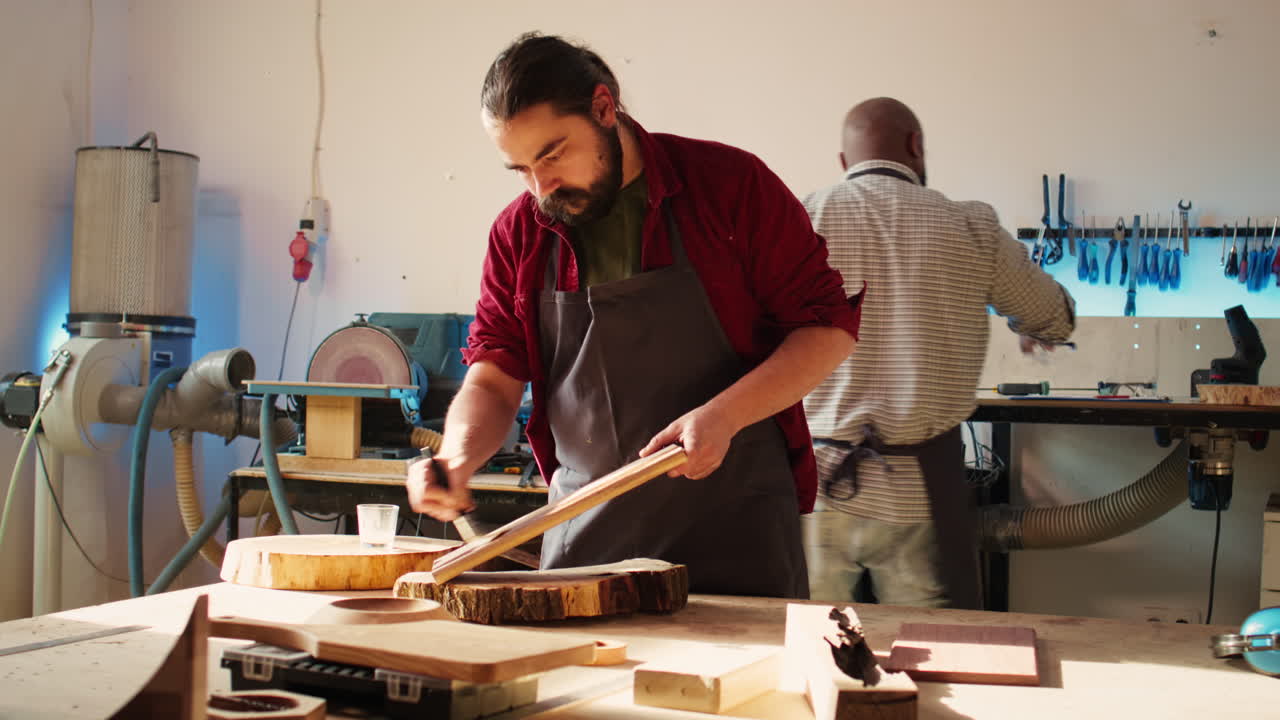 experto en carpintería en el estudio haciendo poner capas de aceite en la tabla de madera