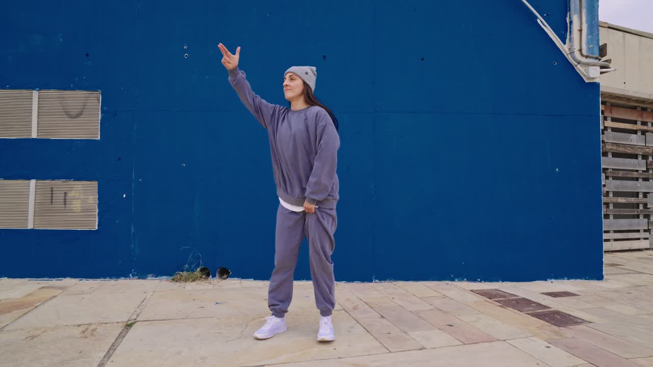 Una donna che balla davanti a un muro blu