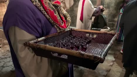 communion cups with wine being passed out at a holiday christmas event at a local church