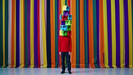 surreal image of a boy wearing a stack of colorful cubes with eyes on his head, standing in front of a vibrant, striped curtain backdrop, creating a visually striking and thought provoking scene