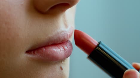 mujer aplicando lápiz labial