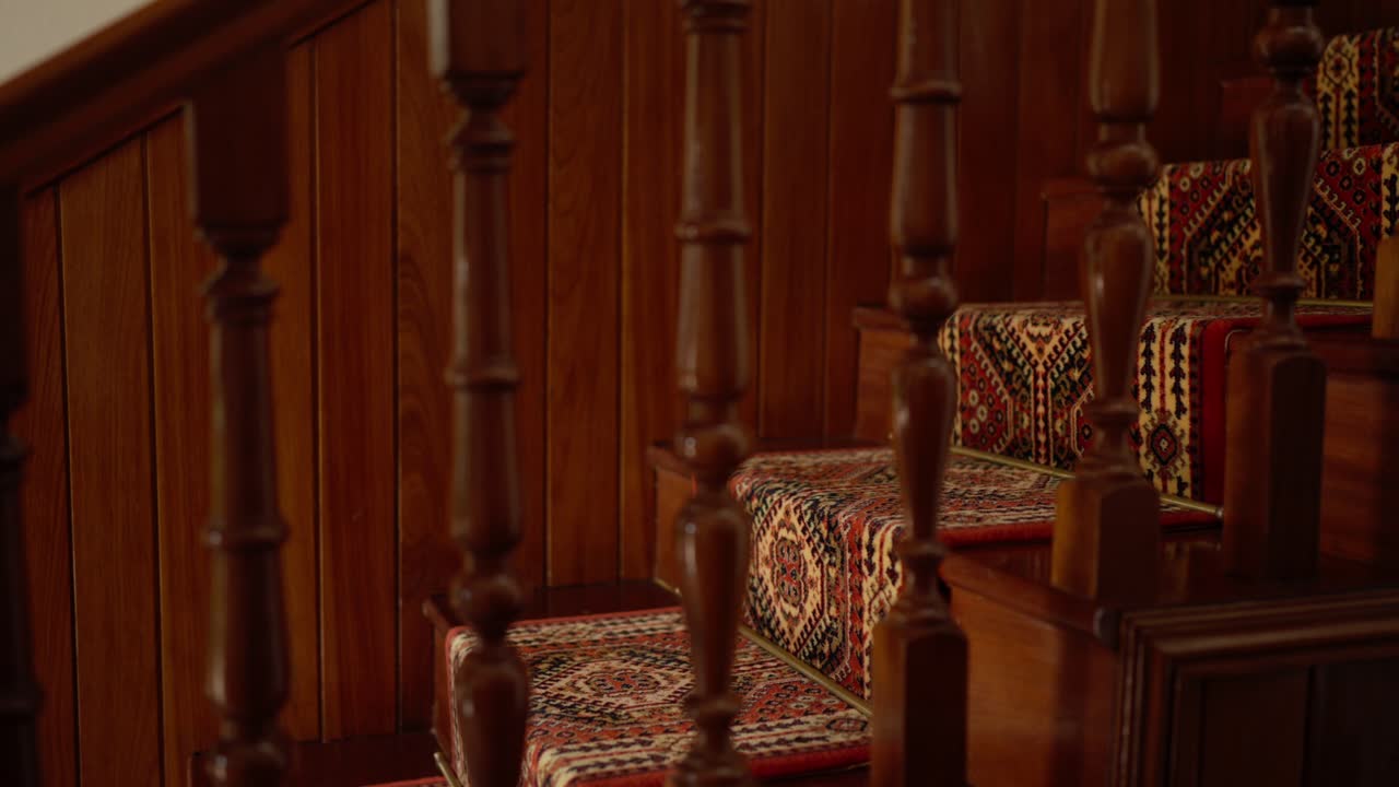 색 바지 와 갈색 신발 을 입고 카 로 된 나무 계단 을 내려가는 사람