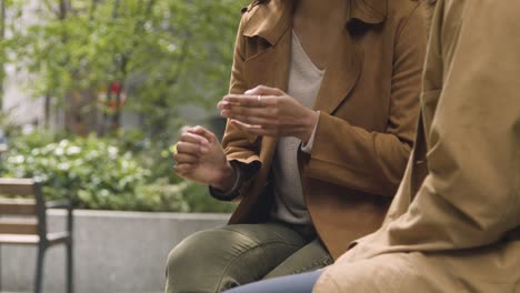 close up of muslim couple on date sitting and talking together on city street 1