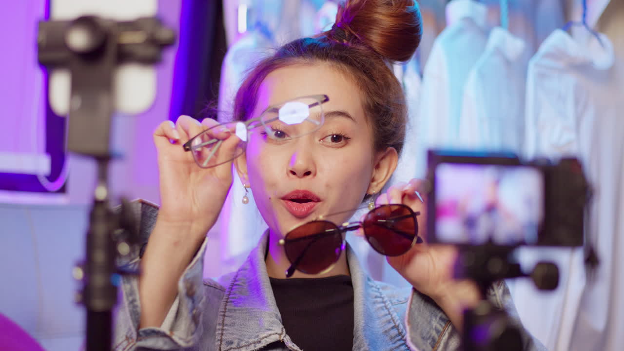 una joven vibrante muestra gafas de moda en un ambiente de estudio animado capturando la atención con su expresión alegre.