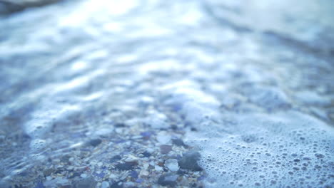 Rocky-Beachfront-With-Calm-Waves-Washing-The-Shore-During-Daytime