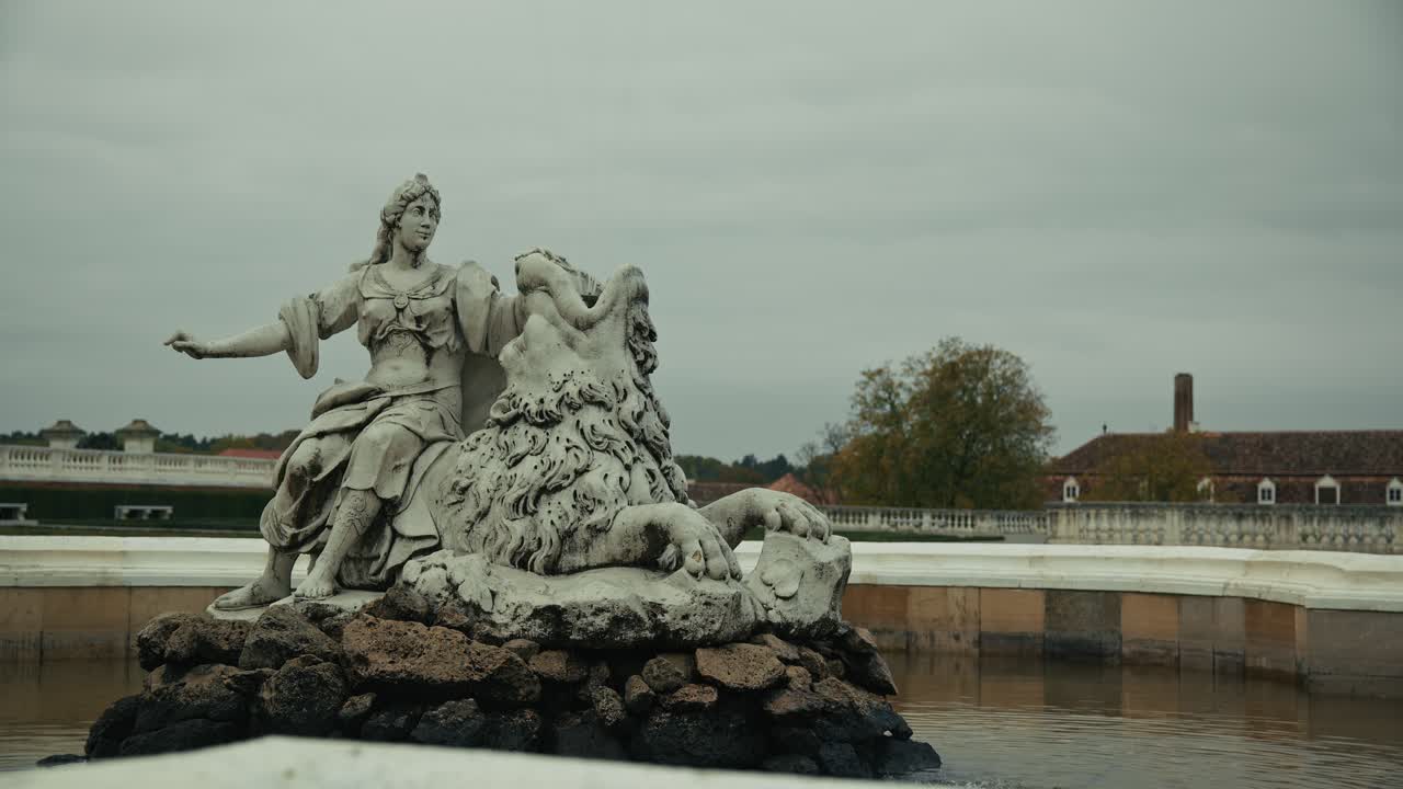 Ornate baroque fountain sculpture of a woman and lion at Schloss Hof, Austria