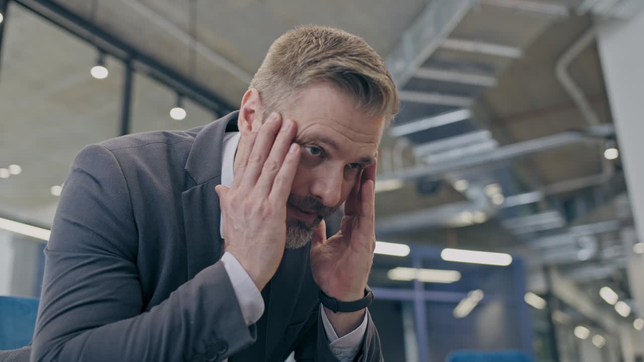 hombre de negocios angustiado con migraña, frotando las sienes, cansado del trabajo estresante