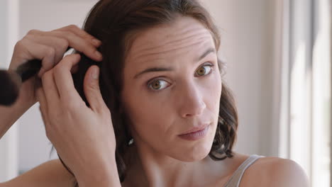 retrato de una mujer hermosa aplicando maquillaje preparándose en casa mirándose en el espejo disfrutando de la tez natural preparación matutina