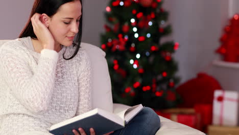 pretty brunette reading book at christmas time