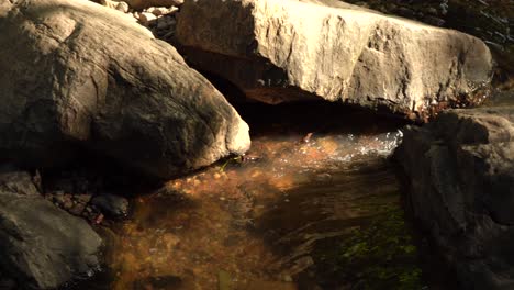 Beautiful-river-stream-trickling-down-rocky-mountainside-at-sunset