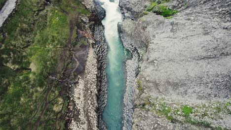 drone volando hacia abajo con la cámara inclinándose hacia arriba en el cañón studlagil en islandia 4k