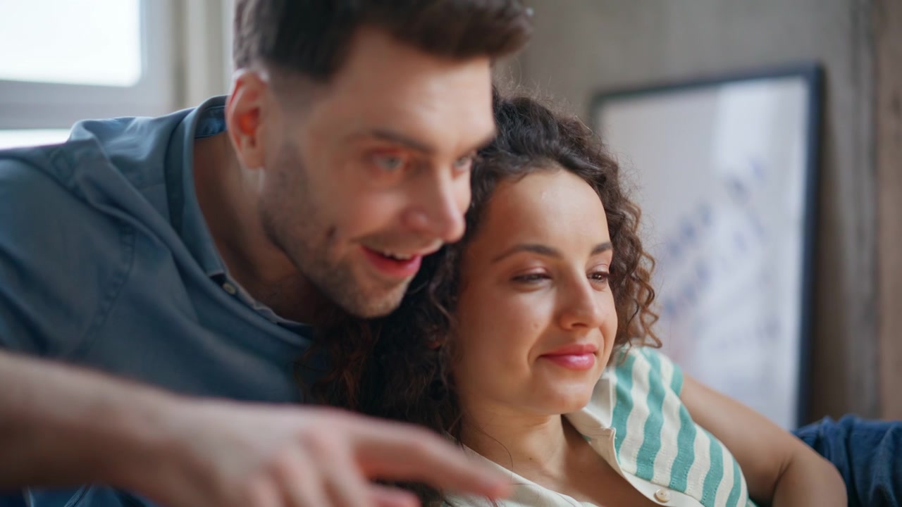 Loving man embracing girlfriend home. Close up couple looking laptop weekend