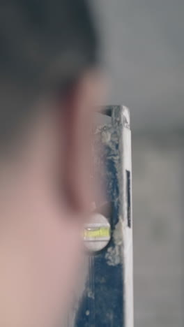 blurred man head nape with shot dark haircut against large measuring ruler prepared for flat repairing extreme closeup