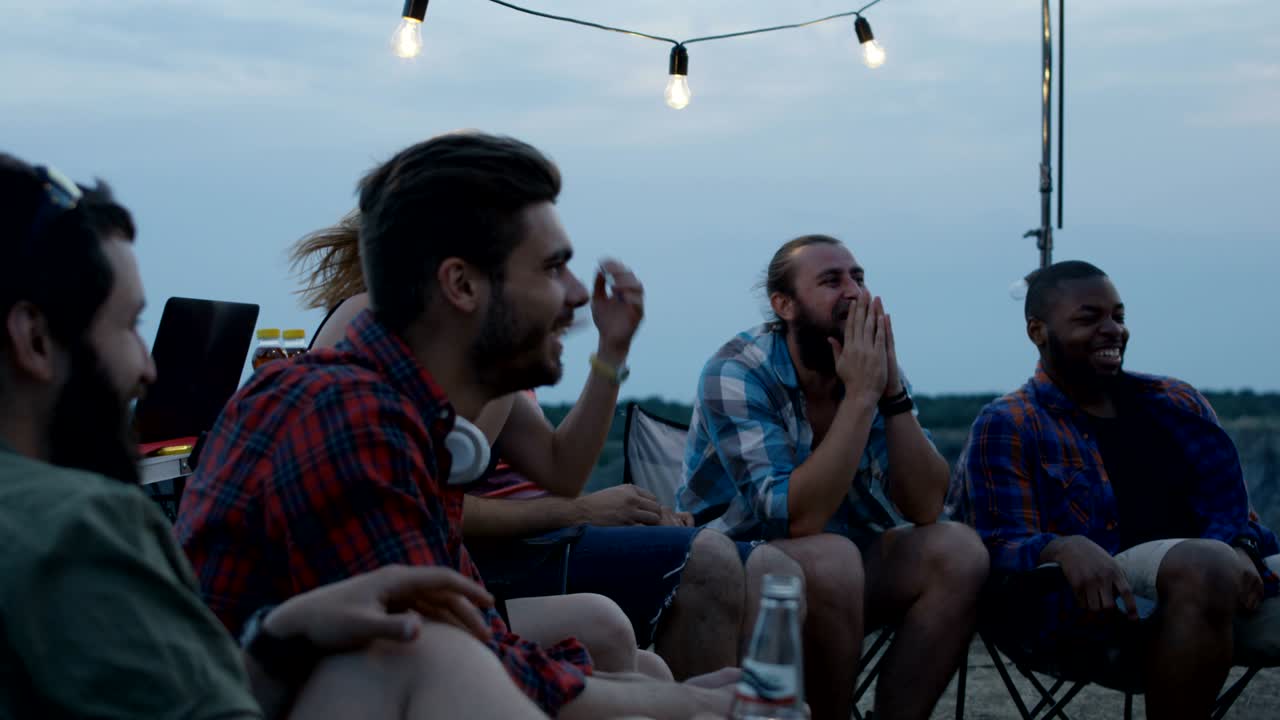Laughing diverse friends playing charades in camp