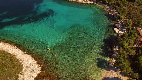 people kayaking in sea, green nature and islands